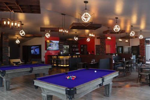 a billiard room with two pool tables and a bar at Hotel Wellintown in Tijuana