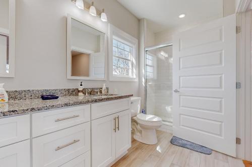 a white bathroom with a toilet and a sink at Blooming Fields in Nashville