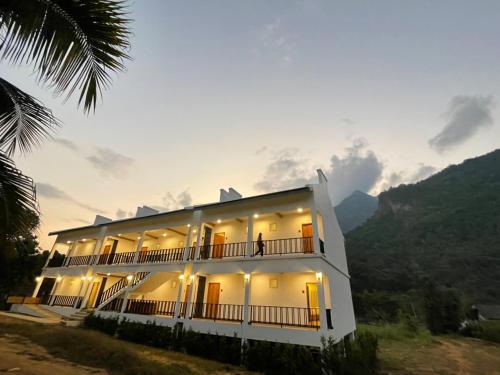 a large white building with a mountain in the background at DOI LUANG SCENE in Ban Tham
