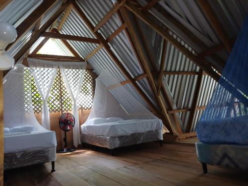 a attic room with two beds and a window at Casa Manatí in Lívingston