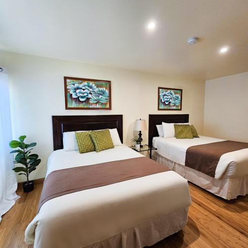 two beds in a hotel room with two beds at Hotel Partenon Beach in La Ceiba