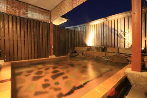 an indoor hot tub in a patio at night at 旅館　松乃湯 in Kutami