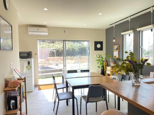 eine Küche und ein Esszimmer mit einem Tisch und Stühlen in der Unterkunft ゲストハウス and BAR CHITEN in Awaji