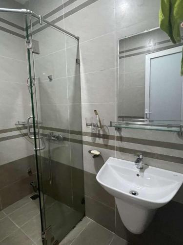 a bathroom with a glass shower and a sink at Khu phố Water Front in Hai Phong