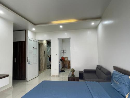 1 dormitorio con 1 cama azul y 1 sofá en Khu phố Water Front, en Hai Phong