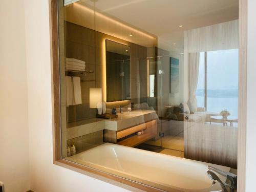 ハロンにあるBayside Bliss Apartment By A La Carte Ha Long Ocean Viewの浴槽、洗面台、鏡のあるバスルーム
