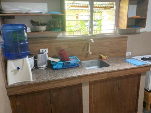 a kitchen counter top with a sink and a window at Panglao Vacation Home in Panglao Island