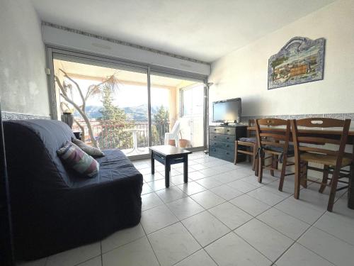 un salon avec un canapé et une salle à manger dans l'établissement Charmant T2 avec terrasse, parking privé, à 300m de la plage - FR-1-309-432, à Banyuls-sur-Mer