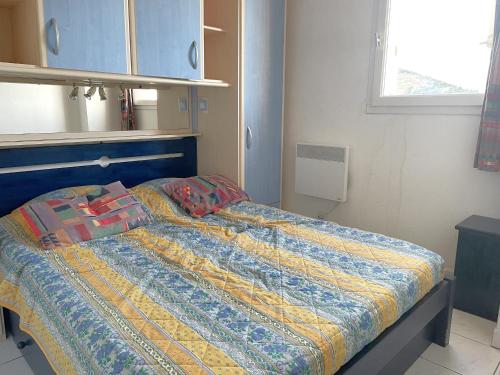 une chambre avec un lit avec une couette dessus dans l'établissement Charmant T2 avec terrasse, parking privé, à 300m de la plage - FR-1-309-432, à Banyuls-sur-Mer