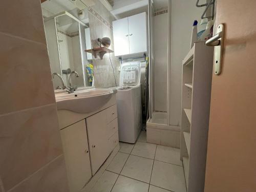 La salle de bains blanche est pourvue d'un évier et d'un réfrigérateur. dans l'établissement Charmant T2 avec terrasse, parking privé, à 300m de la plage - FR-1-309-432, à Banyuls-sur-Mer
