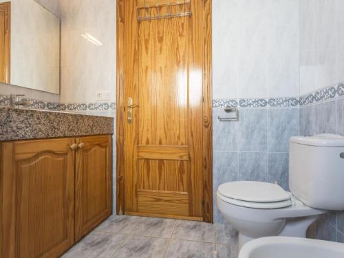 uma casa de banho com um WC e uma porta de madeira em Casa L'Escala, 3 dormitorios, 7 personas - ES-325-15 em Torroella de Montgrí