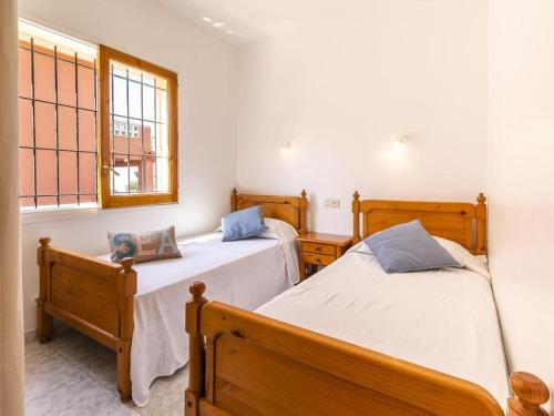 a bedroom with two beds and a window at Casa L'Escala, 4 dormitorios, 8 personas - ES-325-12 in Torroella de Montgrí