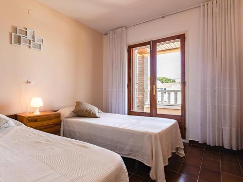 2 Betten in einem Zimmer mit Fenster in der Unterkunft Casa L'Escala, 4 dormitorios, 8 personas - ES-325-33 in Torroella de Montgrí