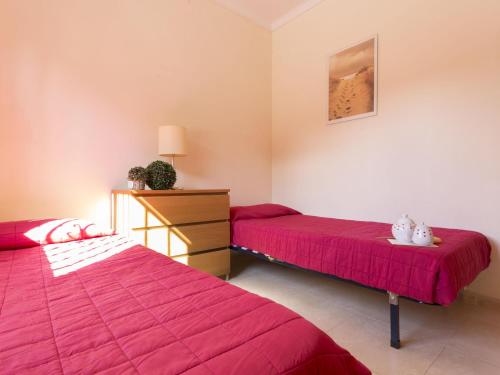 duas camas num quarto com lençóis vermelhos em Casa L'Escala, 3 dormitorios, 6 personas - ES-325-22 em Torroella de Montgrí