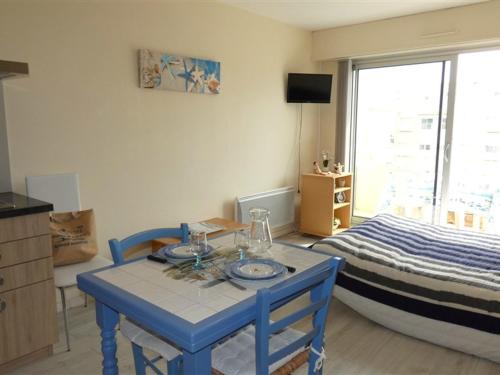 - une chambre avec une table bleue et un lit dans l'établissement Studio cosy proche plage et commerces, parking inclus - FR-1-323-528, à Saint-Jean-de-Monts