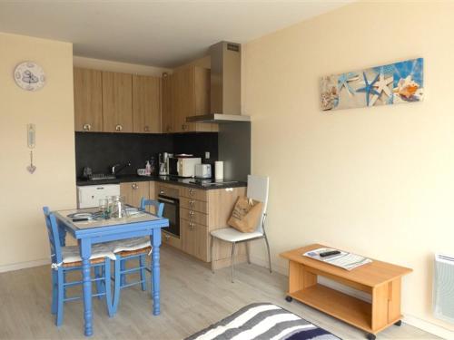 une petite cuisine avec une table bleue et une table dans l'établissement Studio cosy proche plage et commerces, parking inclus - FR-1-323-528, à Saint-Jean-de-Monts