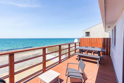 a balcony with a picnic table and chairs on the beach at KAMOME SLOW HOTEL in Awaji