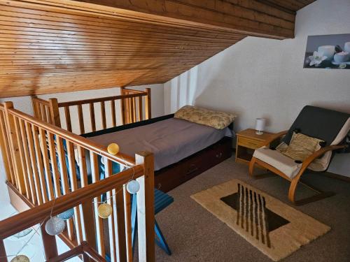 een kleine slaapkamer met een bed en een stoel bij Appartement Arcachon, 3 pièces, 6 personnes - FR-1-319-543 in Arcachon