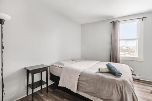 Schlafzimmer mit einem Bett mit einem Tisch und einem Fenster in der Unterkunft Spacious 3 bedroom apartment in Lasalle - 72 in Montreal