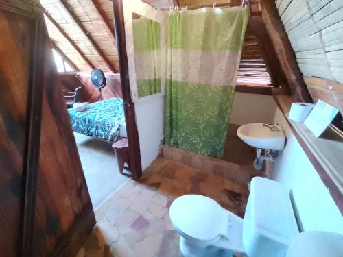 a small bathroom with a toilet and a sink at Hotel Palma Coco in Ayampe