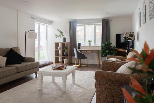 a living room with a couch and a table at Stylish Bungalow in Symonds Yat in Hereford