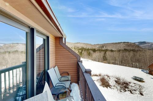 a balcony with two chairs and a view of the mountains at White Birch at Nordic Village in Bartlett