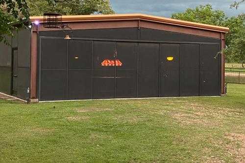 a large black garage with a sign on it at 4 Cabins - Reindeer Ranch at Round Top in Carmine