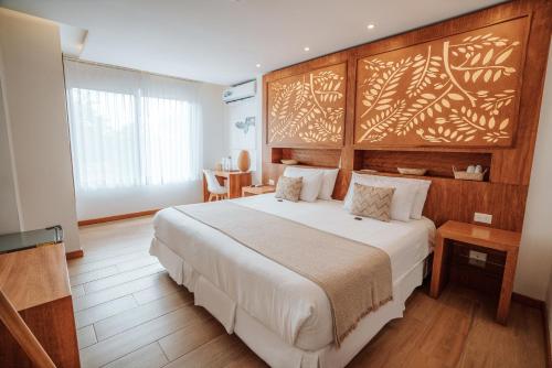 1 dormitorio con 1 cama grande y cabecero de madera en Hotel Acacia, en Puerto Ayora
