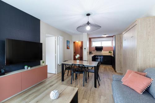 un salon avec une table et une télévision dans l'établissement Superbe terrasse et appart - La plage à pied - 4pers., à Guérande