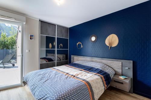 une chambre avec un mur bleu avec un lit dans l'établissement Superbe terrasse et appart - La plage à pied - 4pers., à Guérande