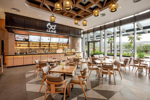 ハロンにあるBayside Bliss Apartment By A La Carte Ha Long Ocean Viewのテーブルと椅子とバーのあるレストラン