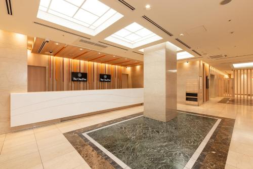 a lobby with a reception desk and a skylight at The OneFive Osaka Namba Dotonbori in Osaka