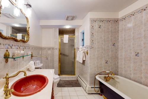 y baño con lavabo rojo y bañera. en Stoney Manor, en Pocono Pines
