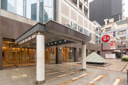 un edificio con un passaggio pedonale nel centro di una città di The OneFive Osaka Namba Dotonbori ad Osaka