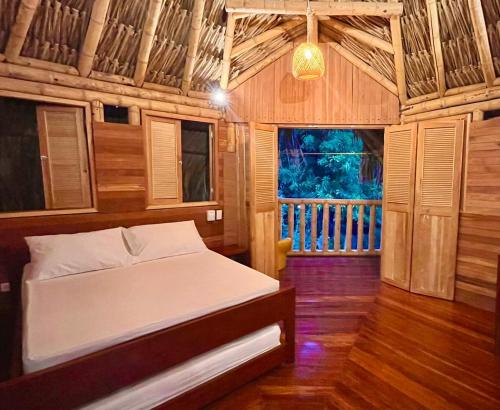 a bedroom with a bed in a wooden room at Las Cabanas de Pino Hostel in Santa Fe de Antioquia