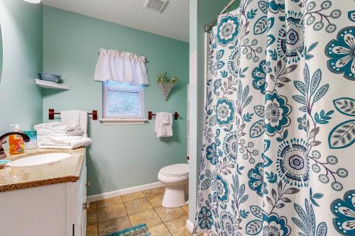 y baño con aseo y cortina de ducha. en 4628 Whimbrel Lane, en Fernandina Beach