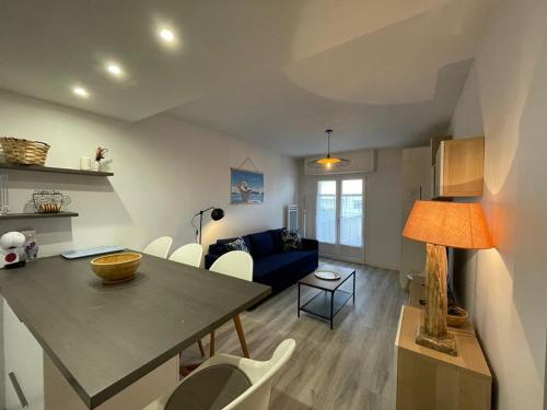 une cuisine et un salon avec une table et des chaises dans l'établissement Charmant appart rénové, 4 pers, 50m plage, WiFi, cour/terrasse, Capbreton - FR-1-413-239, à Capbreton