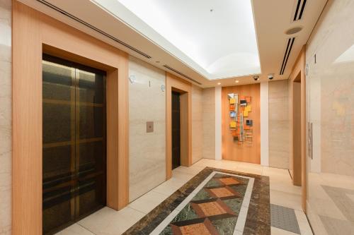 a hallway with a glass door and a rug at The OneFive Osaka Namba Dotonbori in Osaka