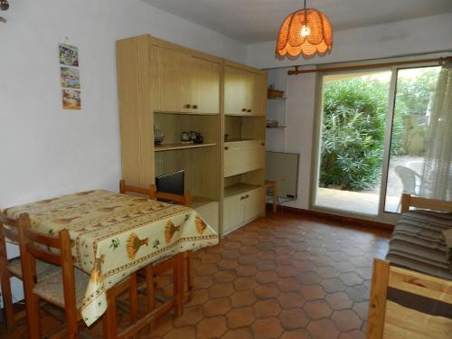une cuisine avec une table et une salle à manger avec une fenêtre dans l'établissement Appartement avec Terrasse et Garage, 250m Plage - Bormes-les-Mimosas - FR-1-251-719, à Bormes-les-Mimosas
