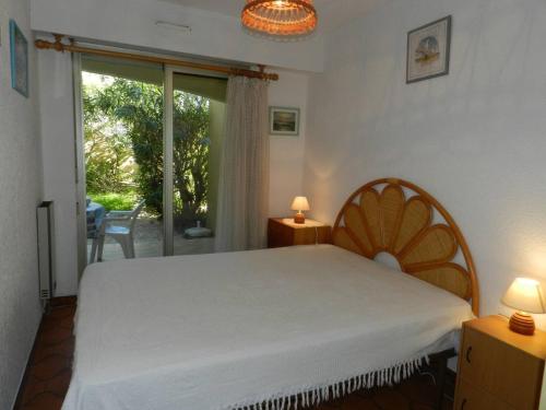 - une chambre avec un lit blanc et une porte coulissante en verre dans l'établissement Appartement avec Terrasse et Garage, 250m Plage - Bormes-les-Mimosas - FR-1-251-719, à Bormes-les-Mimosas
