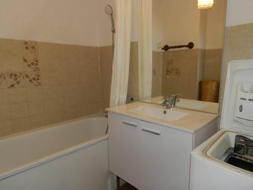 une salle de bain avec un lavabo et une baignoire dans l'établissement Appartement avec Terrasse et Garage, 250m Plage - Bormes-les-Mimosas - FR-1-251-719, à Bormes-les-Mimosas