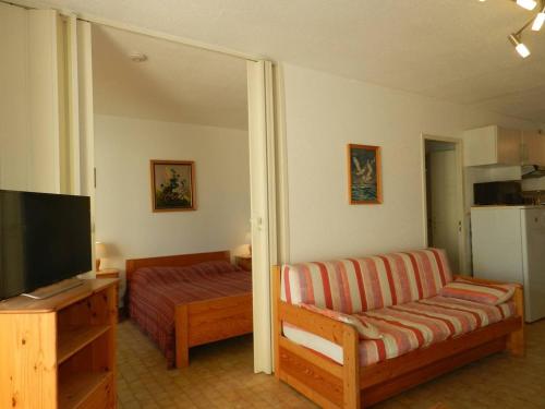 un salon avec un canapé et une télévision dans l'établissement Appartement 2 Pièces au Lavandou avec Terrasse, Wi-Fi et Parking Privé à 5min de la Plage - FR-1-251-710, au Lavandou