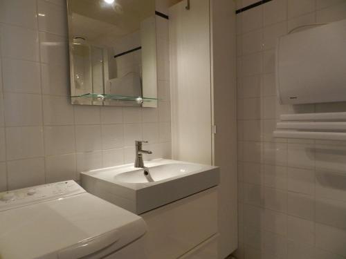 une salle de bain blanche avec un lavabo et un miroir dans l'établissement Appartement rénové avec accès plage, piscine et tennis - Bormes-les-Mimosas - FR-1-251-730, à Bormes-les-Mimosas