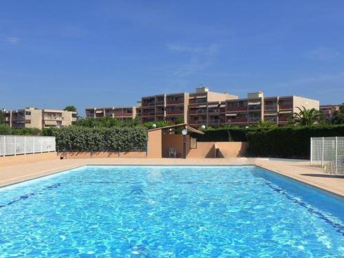 une grande piscine devant un immeuble dans l'établissement Appartement rénové avec accès plage, piscine et tennis - Bormes-les-Mimosas - FR-1-251-730, à Bormes-les-Mimosas