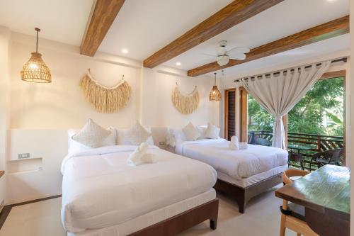 a bedroom with two beds and a balcony at Bulan Villas Siargao in General Luna