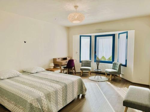a bedroom with a bed and a desk and chairs at Maison lumineuse La Forêt-Fouesnant proche plage, golf, avec salle de détente et 5 chambres - FR-1-481-158 in La Forêt-Fouesnant