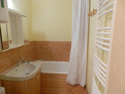 uma casa de banho com um lavatório e uma banheira em Appartement Bormes-les-Mimosas, 1 pièce, 2 personnes - FR-1-251-728 em Bormes-les-Mimosas