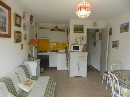 - une cuisine avec un canapé et une table dans une chambre dans l'établissement Appartement cosy près de la plage à Bormes-les-Mimosas - 4 couchages, garage inclus - FR-1-251-713, à Bormes-les-Mimosas