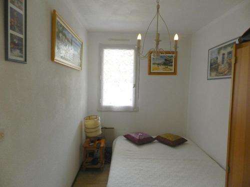 een kleine slaapkamer met een bed en een raam bij Appartement Bormes-les-Mimosas, 2 pièces, 4 personnes - FR-1-251-713 in Bormes-les-Mimosas