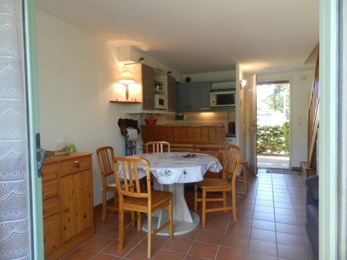 une cuisine et une salle à manger avec une table et des chaises dans l'établissement Duplex 3 pièces climatisé avec piscine, terrasse et parking - Idéal famille au Lavandou - FR-1-251-732, au Lavandou